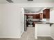 Bright kitchen with stainless steel appliances, dark wood cabinets, and tile flooring throughout at 1880 Fuller Dr, Clearwater, FL 33755
