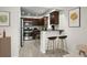Modern kitchen with stainless steel appliances, dark wood cabinets, and breakfast bar with stools at 1880 Fuller Dr, Clearwater, FL 33755