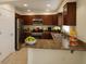 Well-lit kitchen with stainless steel appliances, dark wood cabinets, and ample counter space at 1880 Fuller Dr, Clearwater, FL 33755