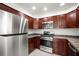 A modern kitchen with stainless steel appliances and ample counter space on dark wooden cabinetry at 1880 Fuller Dr, Clearwater, FL 33755