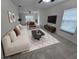 Living room features modern decor, a white sofa, and a geometric rug over tile floors at 1880 Fuller Dr, Clearwater, FL 33755