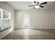 Bright and spacious living room with neutral walls, tiled floors, and a glass panel back door at 1880 Fuller Dr, Clearwater, FL 33755