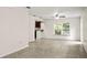 Bright living room with neutral walls, tile floors, and ceiling fan adjacent to the kitchen at 1880 Fuller Dr, Clearwater, FL 33755