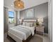 Bedroom with decorative light fixture, window with blinds, soft color scheme, and matching nightstands at 18913 Indian Rock Pl, Lakewood Ranch, FL 34211