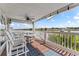 Charming outdoor balcony with beautiful water view, comfortable seating, ceiling fan, and classic blue outdoor rug at 20019 Gulf Blvd # 1, Indian Shores, FL 33785