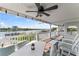 Inviting outdoor balcony with comfortable seating, ceiling fan, and serene water views at 20019 Gulf Blvd # 1, Indian Shores, FL 33785