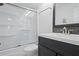 Bright bathroom featuring a sleek vanity with modern fixtures and a glass-enclosed shower/tub combination at 20019 Gulf Blvd # 1, Indian Shores, FL 33785
