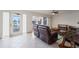 Comfortable living room featuring tile floors, ceiling fan, and outdoor access with a view at 20019 Gulf Blvd # 1, Indian Shores, FL 33785