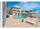 Relaxing pool area surrounded by comfortable lounge chairs, lush palm trees, and pavers at 20019 Gulf Blvd # 1, Indian Shores, FL 33785
