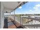 Inviting porch with wood floors, white railings, dining set, and scenic waterfront views on a sunny day at 20019 Gulf Blvd # 1, Indian Shores, FL 33785