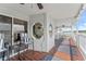 Relaxing porch features a seating area, wood floors, stylish rugs, and peaceful waterfront views at 20019 Gulf Blvd # 1, Indian Shores, FL 33785