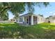 Charming backyard featuring a screened porch, lush lawn and mature trees at 203 Montara Dr, Seffner, FL 33584