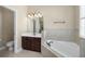 Bathroom featuring a soaking tub, tile surround, and a dark wood vanity with a white countertop at 203 Montara Dr, Seffner, FL 33584