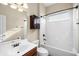 Bathroom features a shower-tub combo and a wooden cabinet, with white tile throughout at 203 Montara Dr, Seffner, FL 33584