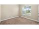 Empty bedroom with a large window that lets in plenty of natural light, and neutral colored carpet and walls at 203 Montara Dr, Seffner, FL 33584
