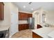 Open kitchen with stainless steel refrigerator, tile floors, and wood cabinetry at 203 Montara Dr, Seffner, FL 33584