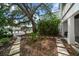 Landscaped backyard with lush greenery, stone pathways, and mature trees leading to waterfront views at 215 18Th Ave, Indian Rocks Beach, FL 33785