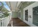 Covered balcony with white railing, ceiling fan, wood floors and access to the building at 215 18Th Ave, Indian Rocks Beach, FL 33785