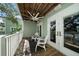 Charming balcony with a wooden floor, ceiling fan, and comfortable white seating, offering a relaxing outdoor space at 215 18Th Ave, Indian Rocks Beach, FL 33785
