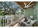 Relaxing balcony with chairs, a ceiling fan, and scenic views of lush greenery and tranquil waterfront at 215 18Th Ave, Indian Rocks Beach, FL 33785