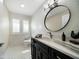 Elegant bathroom featuring a dark vanity with a white countertop, an oval mirror and decorative accents at 215 18Th Ave, Indian Rocks Beach, FL 33785