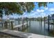 Dock with weathered wood pilings overlooking calm water with boat and houses in the distance at 215 18Th Ave, Indian Rocks Beach, FL 33785