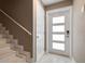 Hallway featuring marble stairs and a decorative glass front door, and a neutral color palette at 215 18Th Ave, Indian Rocks Beach, FL 33785
