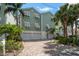 Inviting two-story home featuring a brick driveway, two-car garage and lush landscaping at 215 18Th Ave, Indian Rocks Beach, FL 33785