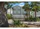 Charming two-story townhome with a two car garage, lush tropical landscaping, and a light green color at 215 18Th Ave, Indian Rocks Beach, FL 33785