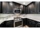 Close up of a modern kitchen featuring stainless steel appliances, granite countertops, and wood cabinets at 215 18Th Ave, Indian Rocks Beach, FL 33785