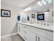 Bathroom featuring a white dual sink vanity with a quartz countertop, modern lighting, and wall-mounted TV at 223 Island Way # 7F, Clearwater Beach, FL 33767