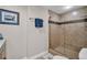 Bathroom featuring a tiled shower with a glass door, decorative tilework, and a neutral color scheme at 223 Island Way # 7F, Clearwater Beach, FL 33767