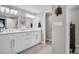 Bright bathroom featuring dual sinks, a white vanity with stone countertop, and modern lighting at 223 Island Way # 7F, Clearwater Beach, FL 33767