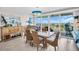 Elegant dining room featuring a rustic wood table, wicker chairs, and sliding doors to a balcony with stunning views at 223 Island Way # 7F, Clearwater Beach, FL 33767