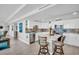 Bright kitchen featuring white cabinetry, stainless appliances, island with barstool seating, with views to the living area at 223 Island Way # 7F, Clearwater Beach, FL 33767