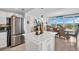 Open kitchen featuring stainless steel refrigerator and large island with seating adjacent to dining area and outside views at 223 Island Way # 7F, Clearwater Beach, FL 33767
