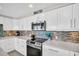 Bright, modern kitchen with white cabinetry, quartz countertops, stainless appliances, and sleek tiled backsplash at 223 Island Way # 7F, Clearwater Beach, FL 33767