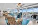 Bright living room featuring floor-to-ceiling windows, comfortable furniture, and a fan at 223 Island Way # 7F, Clearwater Beach, FL 33767