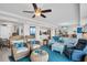 Open-concept living space with a large blue rug, coastal furniture, and plenty of natural light at 223 Island Way # 7F, Clearwater Beach, FL 33767