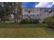 Exterior view of the property featuring a well-maintained lawn and mature trees at 2441 Persian Dr # 61, Clearwater, FL 33763