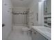 Bathroom with white marble tile, gray vanity, and shower-tub combo at 2441 Persian Dr # 61, Clearwater, FL 33763
