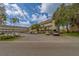 Building exterior view shows mature trees, covered parking, and well-maintained grounds at 2441 Persian Dr # 61, Clearwater, FL 33763