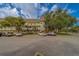 The exterior of building shows balconies and mature trees at 2441 Persian Dr # 61, Clearwater, FL 33763