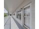 Exterior view of a condo entrance featuring a screened door, white trim, and views of the surrounding community at 2441 Persian Dr # 61, Clearwater, FL 33763