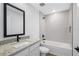 Modern bathroom featuring a granite vanity, tiled shower, and contemporary fixtures at 2464 Fairview Ln, Spring Hill, FL 34609