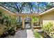 Secluded courtyard featuring brick flooring, arched entryways, wrought iron gate, and lush garden at 2503 Victarra Cir, Lutz, FL 33559