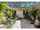 Inviting courtyard with a koi pond, brick pavers, lush plants, and double doors at 2503 Victarra Cir, Lutz, FL 33559