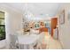 Charming dining area open to living room and kitchen with a chandelier and white table set at 2503 Victarra Cir, Lutz, FL 33559
