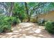 Sun-drenched driveway leading to a two-car garage and charming home surrounded by lush greenery at 2503 Victarra Cir, Lutz, FL 33559