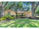 Well-kept home exterior featuring lush lawn, mature shade trees, and manicured hedges at 2503 Victarra Cir, Lutz, FL 33559